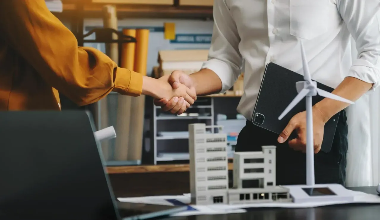 Handshake over a table with architectural building models