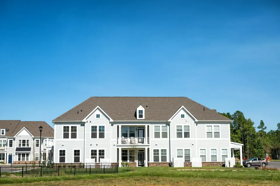 Large white multi-family home on a green lawn, the type of listing a Vietnamese-speaking realtor handles